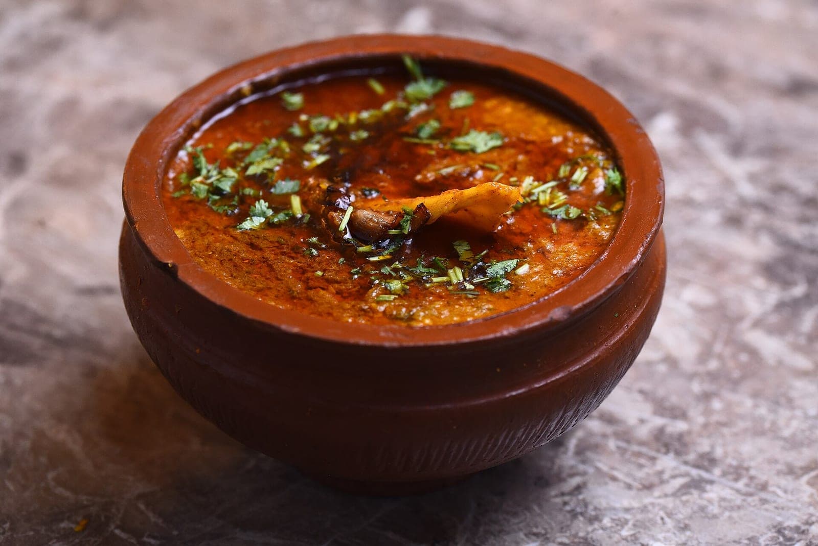 Slow-cooked nihari garnished with ginger and chillies