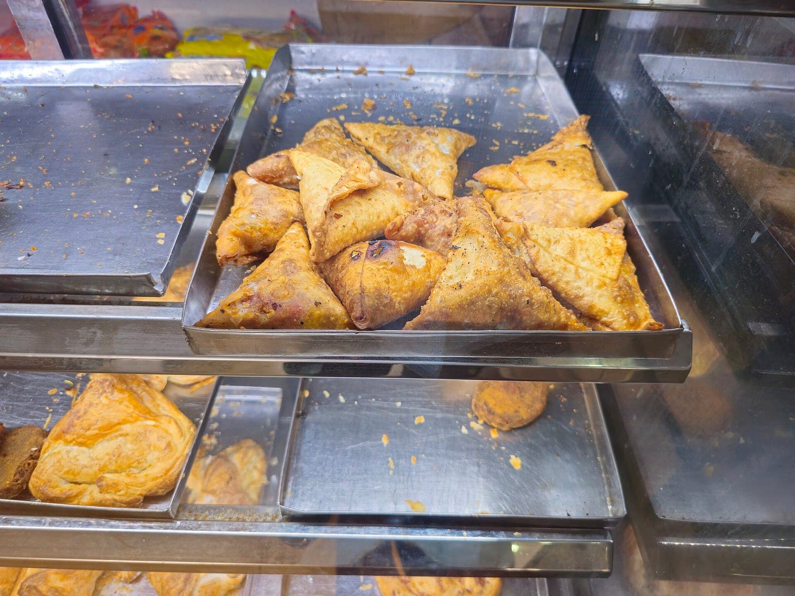 Freshly fried samosas on a tray