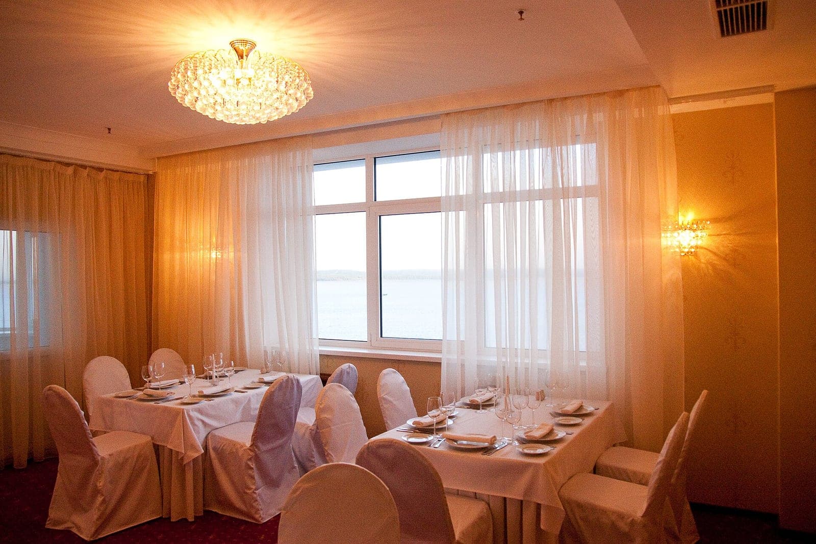 Banquet hall set with dressed tables and chandeliers