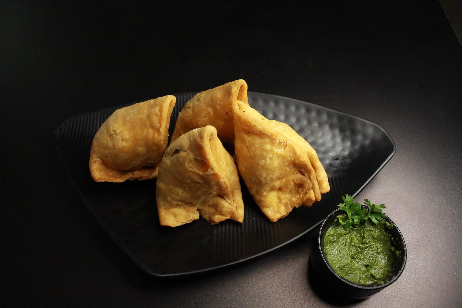 Crisp samosas served with chutney