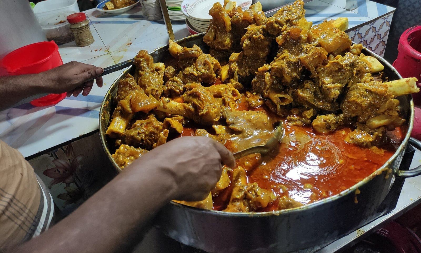 A large pot of slow-cooked nihari being served